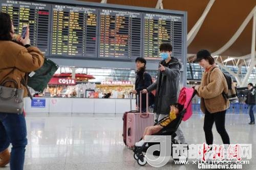 旅客帶著孩子前往辦票柜臺辦理登機手續(xù)。　殷立勤 攝