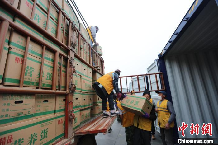 圖為鐵路裝卸作業(yè)人員正在將云南特色農(nóng)產(chǎn)品裝入集裝箱?！詈?攝