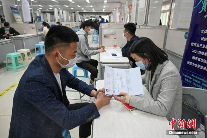 4月14日，招聘者在查看求職者簡歷。<a target='_blank'  data-cke-saved- >中新社</a>記者 王剛 攝