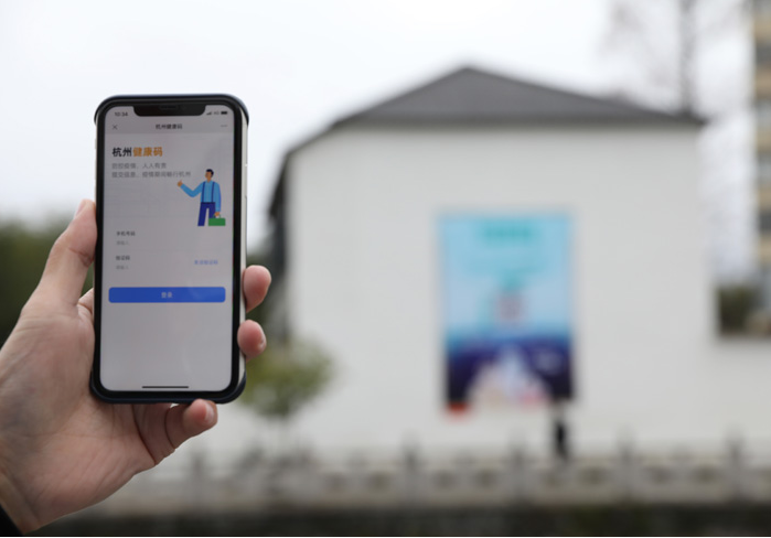 在浙江省杭州市臨安區(qū)天目山鎮(zhèn)，一名居民在“杭州健康碼”海報上掃碼申領(lǐng)個人二維碼。新華社發(fā)