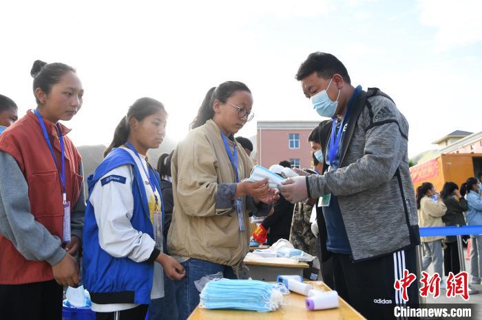 7月7日，考生在拉薩三高考點外領(lǐng)取口罩。　何蓬磊 攝